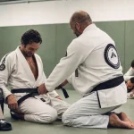Club jiu jitsu bresilien : coach ajuste la ceinture, dojo et essai